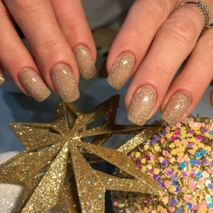 About Us Elegant gold-glittered nails with star decorations, perfect for festive occasions.