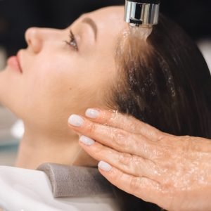 Home Close-up of a woman getting her hair washed at a salon, highlighting professional care.